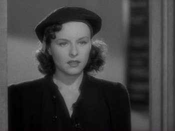 Movie still from “The Young in Heart” (1938), directed by Gilbert Pratt – A black and white photo of a woman wearing a hat; Close Up shot, Over the shoulder angle