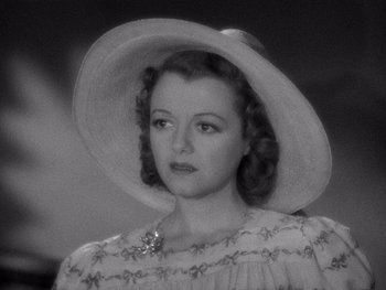 Movie still from “The Young in Heart” (1938), directed by Gilbert Pratt – A woman wearing a white hat and a dress; Close Up shot, High angle