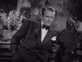 Movie still from “The Young in Heart” (1938), directed by Gilbert Pratt – A black and white photo of a man in a tuxedo; Medium shot, High angle