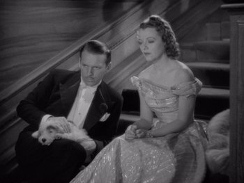 Movie still from “The Young in Heart” (1938), directed by Gilbert Pratt – A man and a woman sitting on a stair case; Medium shot, High angle