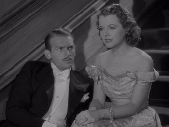 Movie still from “The Young in Heart” (1938), directed by Gilbert Pratt – A man and a woman sitting next to each other in formal wear; Medium shot, High angle