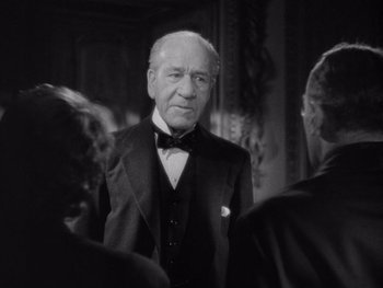 Movie still from “The Young in Heart” (1938), directed by Gilbert Pratt – An older man wearing a suit and bow tie; Close Up shot, Over the shoulder angle
