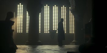Movie still from “House of the Dragon” (2022), created by George R.R. Martin – A person standing in front of a window; Extreme Wide shot, Low angle