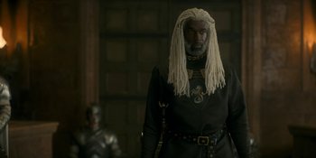 Movie still from “House of the Dragon” (2022), created by George R.R. Martin – A man with a long dreadlocks and a black outfit; Medium shot, Over the shoulder angle