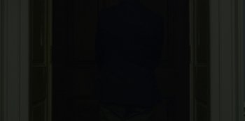 Movie still from “House of Cards” (2013), created by Beau Willimon – A person standing in a dark room with their arms crossed; Medium shot, Low angle