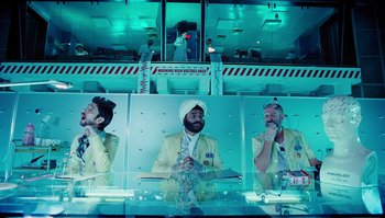 Movie still from “The Zero Theorem” (2013), directed by Terry Gilliam – A group of men sitting at a table in front of a mirror; Medium shot, Low angle