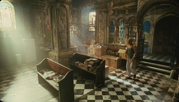 Movie still from “The Zero Theorem” (2013), directed by Terry Gilliam – A woman standing in a room with a lot of furniture on the floor; Wide shot, High angle