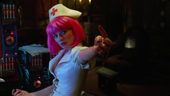 Movie still from “The Zero Theorem” (2013), directed by Terry Gilliam – A woman with pink hair wearing a nurse's uniform; Medium shot, Low angle
