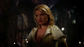 Movie still from “The Zero Theorem” (2013), directed by Terry Gilliam – A woman with blonde hair wearing a white shirt; Close Up shot, Low angle