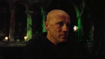 Movie still from “The Zero Theorem” (2013), directed by Terry Gilliam – A man with bald head looking into the distance; Close Up shot, Low angle