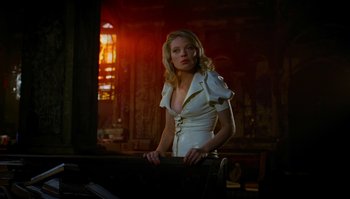 Movie still from “The Zero Theorem” (2013), directed by Terry Gilliam – A woman in a white dress standing next to a window; Medium shot, Low angle