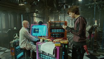 Movie still from “The Zero Theorem” (2013), directed by Terry Gilliam – A man standing in front of a computer screen; Medium shot, Over the shoulder angle