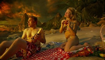 Movie still from “The Zero Theorem” (2013), directed by Terry Gilliam – A man and a woman sitting on a blanket on the beach; Wide shot, Low angle