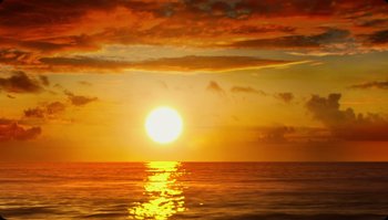 Movie still from “The Zero Theorem” (2013), directed by Terry Gilliam – The sun is setting over the ocean as seen from the beach; Extreme Wide shot, Low angle