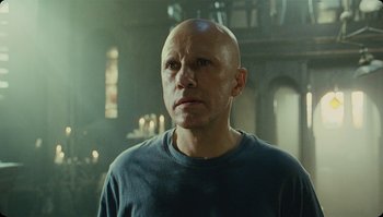 Movie still from “The Zero Theorem” (2013), directed by Terry Gilliam – A bald man is looking into the distance in a room; Close Up shot, Low angle