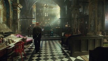 Movie still from “The Zero Theorem” (2013), directed by Terry Gilliam – A man standing inside of a church looking at the floor; Wide shot, High angle