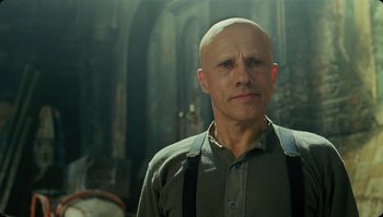 Movie still from “The Zero Theorem” (2013), directed by Terry Gilliam – A man with a bald head is looking at the camera; Close Up shot, Low angle