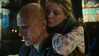 Movie still from “The Zero Theorem” (2013), directed by Terry Gilliam – A man and a woman hugging each other in front of a wall; Close Up shot, Low angle