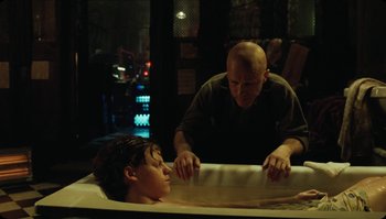Movie still from “The Zero Theorem” (2013), directed by Terry Gilliam – A bald man and a young boy in a bathtub; Medium shot, Over the shoulder angle