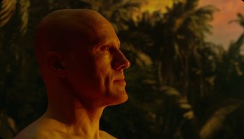 Movie still from “The Zero Theorem” (2013), directed by Terry Gilliam – A man with bald head looking into the distance; Close Up shot, Low angle
