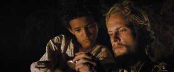 A man and a young boy looking at a cell phone