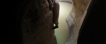 A person climbing up a rock wall in a cave