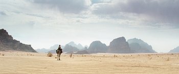 A man riding a camel through the desert