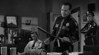 Movie still from “Them!” (1954), directed by Gordon Douglas – An old black and white photo of two men in a room; Medium shot, Over the shoulder angle