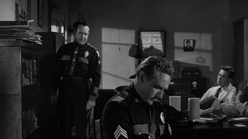 Movie still from “Them!” (1954), directed by Gordon Douglas – Two men in uniform are sitting in a living room; Medium shot, Over the shoulder angle