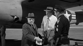 Movie still from “Them!” (1954), directed by Gordon Douglas – A group of men standing next to each other; Medium shot, Over the shoulder angle