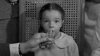 Movie still from “Them!” (1954), directed by Gordon Douglas – A young girl is drinking a glass of water; Close Up shot, Low angle