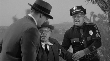 Movie still from “Them!” (1954), directed by Gordon Douglas – A group of men standing next to each other on top of a hill; Medium shot, Over the shoulder angle