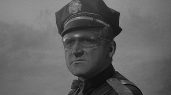 Movie still from “Them!” (1954), directed by Gordon Douglas – An old black and white photo of a police officer; Close Up shot, Low angle