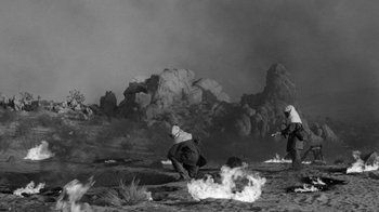 Movie still from “Them!” (1954), directed by Gordon Douglas – Two men are standing in a field near a fire; Extreme Wide shot, High angle