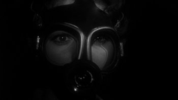 Movie still from “Them!” (1954), directed by Gordon Douglas – A person wearing a gas mask and goggles; Close Up shot, Low angle