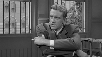 Movie still from “Them!” (1954), directed by Gordon Douglas – Black and white photograph of a man in a suit and tie; Close Up shot, Over the shoulder angle