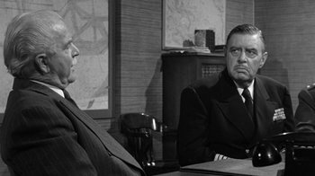 Movie still from “Them!” (1954), directed by Gordon Douglas – Two men sitting at a table in front of each other; Medium shot, Over the shoulder angle