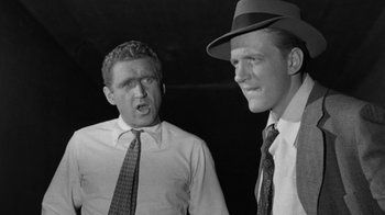 Movie still from “Them!” (1954), directed by Gordon Douglas – Two men in hats and ties standing next to each other; Close Up shot, Low angle