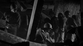 Movie still from “Them!” (1954), directed by Gordon Douglas – A group of men standing next to each other in a building; Medium shot, Low angle