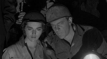 Movie still from “Them!” (1954), directed by Gordon Douglas – A man and a woman in military uniforms looking at the camera; Close Up shot, Low angle