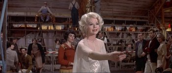 Movie still from “They Shoot Horses, Don't They?” (1969), directed by Sydney Pollack – An older woman in a white dress is holding her hand out to a younger woman; Medium shot, Over the shoulder angle