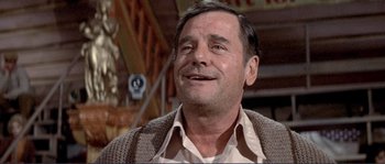 Movie still from “They Shoot Horses, Don't They?” (1969), directed by Sydney Pollack – An older man wearing a brown sweater and smiling; Close Up shot, Low angle