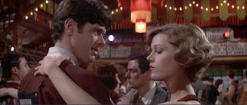 Movie still from “They Shoot Horses, Don't They?” (1969), directed by Sydney Pollack – A man and a woman are talking in front of a crowd; Close Up shot, Low angle