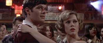 Movie still from “They Shoot Horses, Don't They?” (1969), directed by Sydney Pollack – A man and a woman are standing in front of a crowd; Close Up shot, Low angle