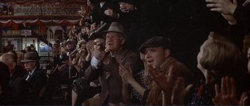 Movie still from “They Shoot Horses, Don't They?” (1969), directed by Sydney Pollack – An old man in a suit and hat clapping in front of an audience; Medium shot, Low angle