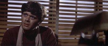 Movie still from “They Shoot Horses, Don't They?” (1969), directed by Sydney Pollack – A man sitting in front of a window with blinds behind him; Close Up shot, Low angle