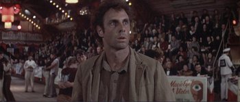 Movie still from “They Shoot Horses, Don't They?” (1969), directed by Sydney Pollack – A man standing in front of a crowd of people; Close Up shot, Low angle