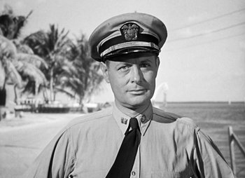 Movie still from “They Were Expendable” (1945), directed by Robert Montgomery – An old black and white photo of a man wearing a hat; Close Up shot, Low angle