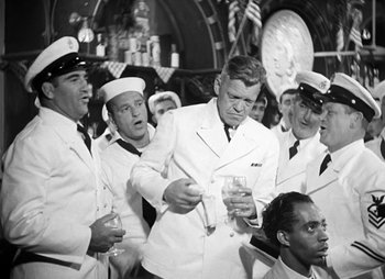 Movie still from “They Were Expendable” (1945), directed by Robert Montgomery – A black and white photo of a group of sailors; Medium shot, Over the shoulder angle