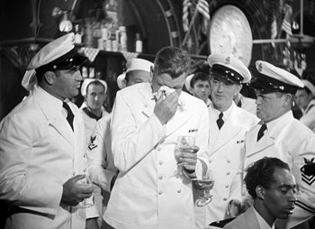 Movie still from “They Were Expendable” (1945), directed by Robert Montgomery – A group of men standing next to each other holding wine glasses; Medium shot, Over the shoulder angle